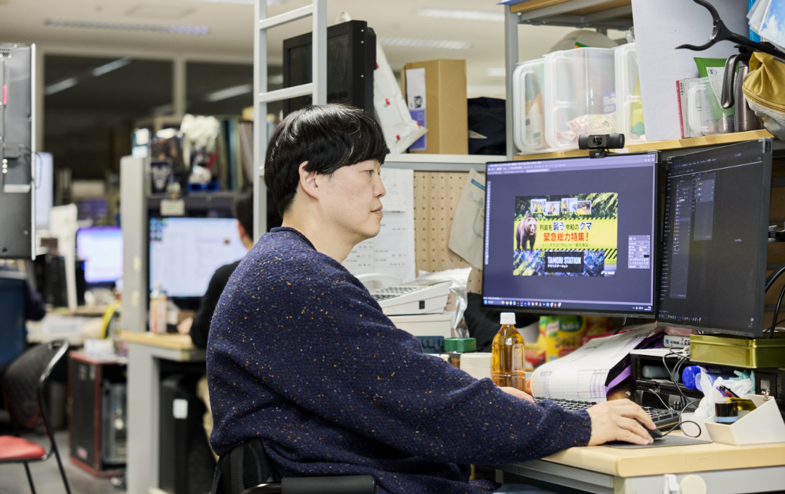 オフィスのデスクでパソコン作業をしている清野さん。画面には制作中の番組テロップが表示されている。