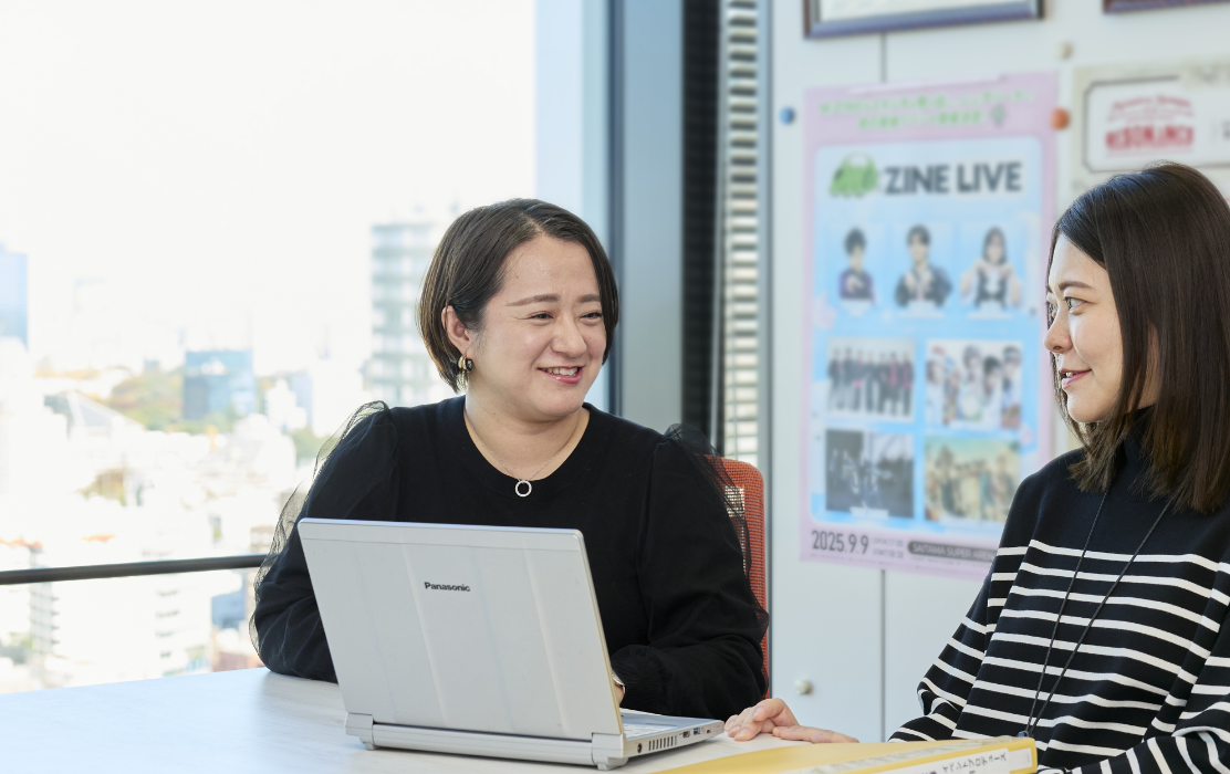 会議室で同僚と談笑している末永さん。