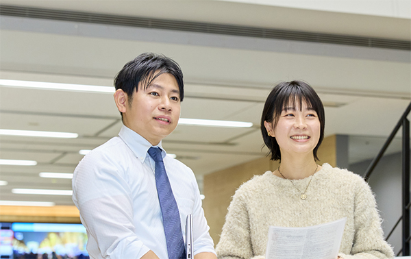 報道局の廊下で同僚と会話をしている八幡原さん。