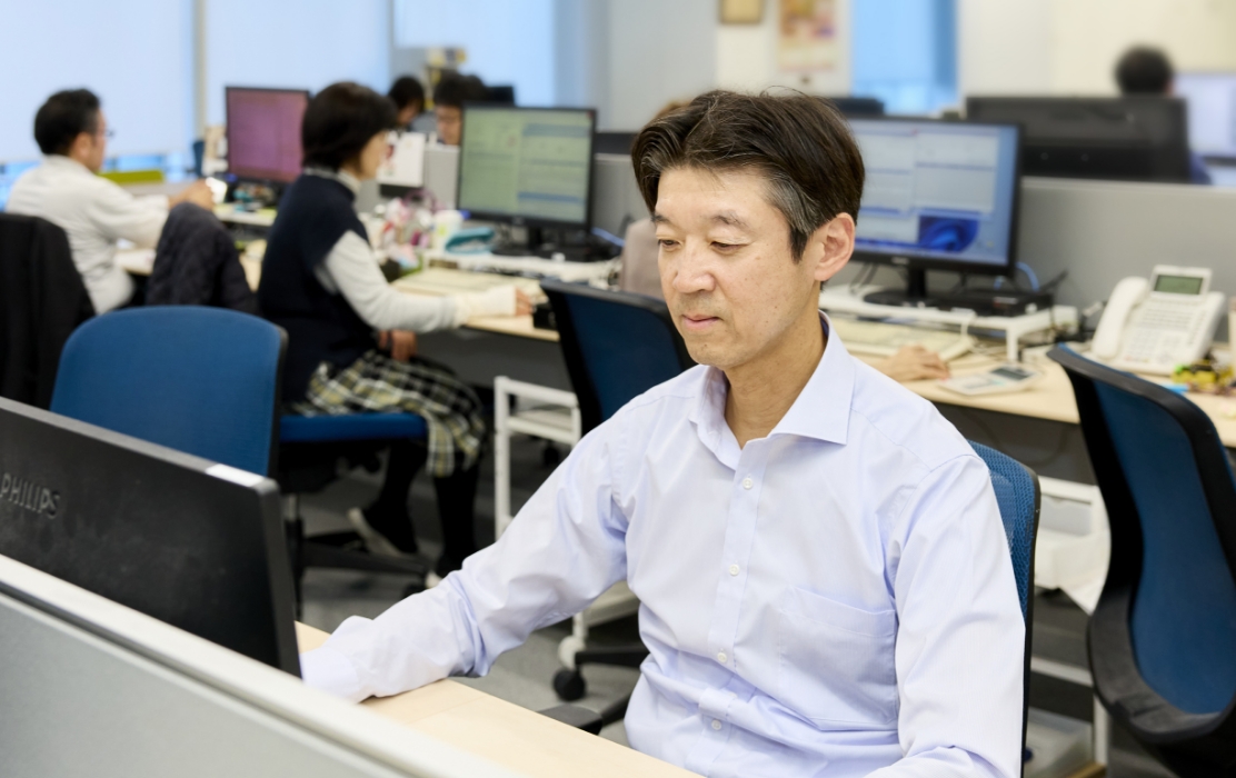 経理局のオフィスで、デスクに向かって作業をしている髙島さん。